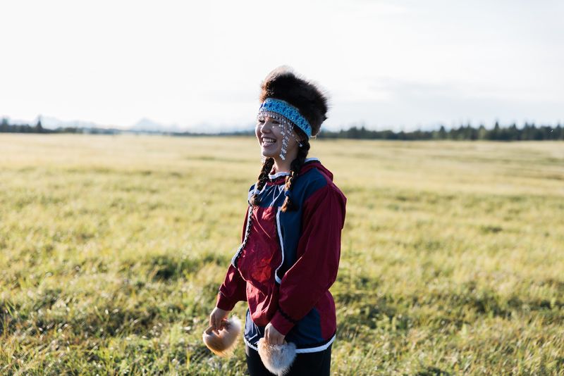 A joyful young woman on the tundra with her dance fans.